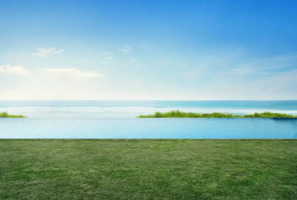 Photo of Empty grass floor deck in luxury beach house with blue sky background, Sea view terrace at vacation home or hotel