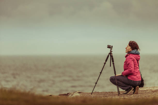 istock Tourist with camera on seashore, Norway 872739714