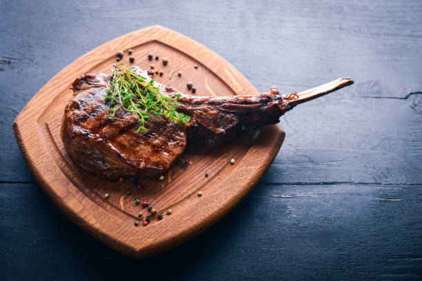 istock Steak on the bone. Top view. Free space for text. On a wooden background. 872743306