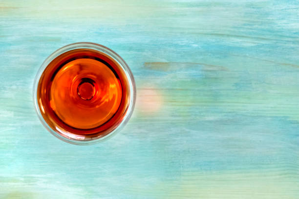 istock Vibrant wine glass on teal background with copy space 872745764