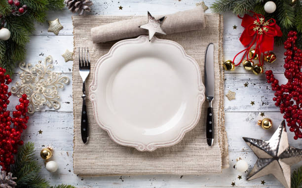 istock Christmas holiday dinner background; empty dish, cutlery and Christmas tree decoration 872756674