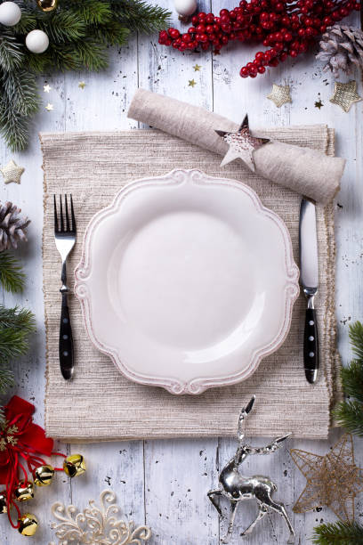 istock Christmas holiday dinner background; empty dish, cutlery and Christmas tree decoration 872756688