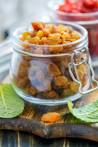 istock Dried grapes in a glass jar closeup. 872757548