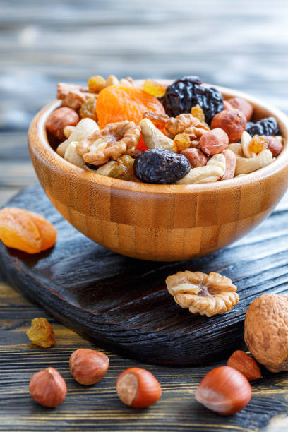 istock Dried fruit and mixed nuts in a wooden bowl. 872760992