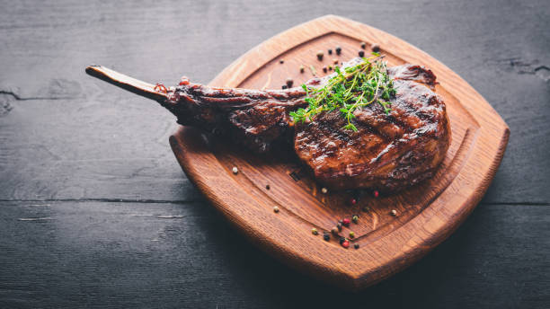 istock Steak on the bone. Top view. Free space for text. On a wooden background. 872761310