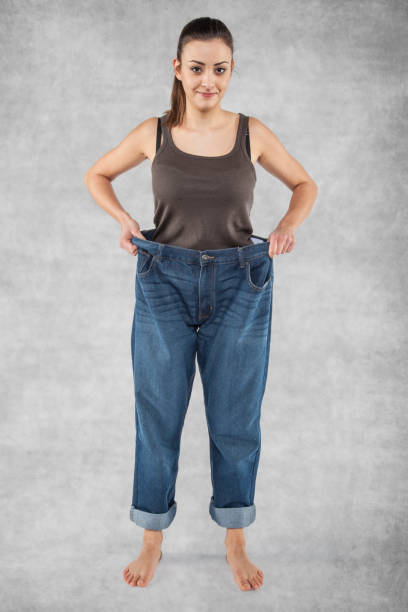 istock Happy girl holding old pants 872764536