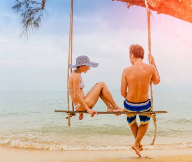istock Couple sitting at rope swings 872769812