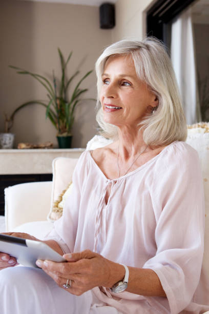 istock older woman sitting at home with digital tablet 872772674