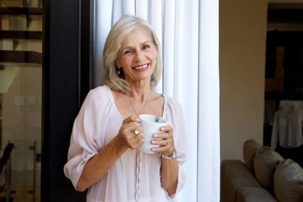 istock smiling woman standing with cup of tea 872772718