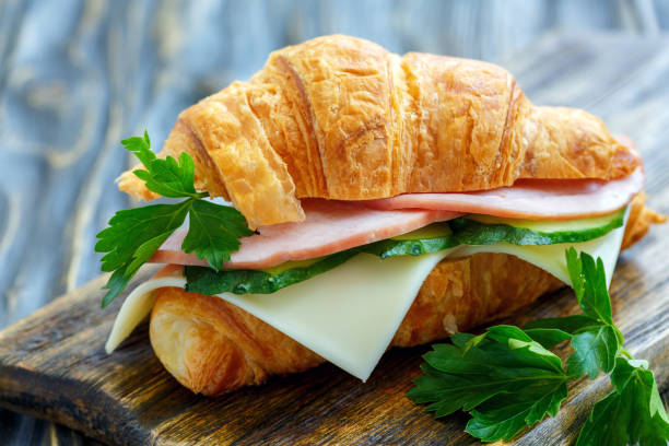 istock Croissant with ham, cheese, cucumber and parsley. 872773372