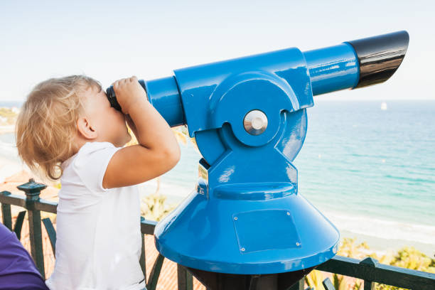 istock Baby girl looking through a paid telescope 872779142