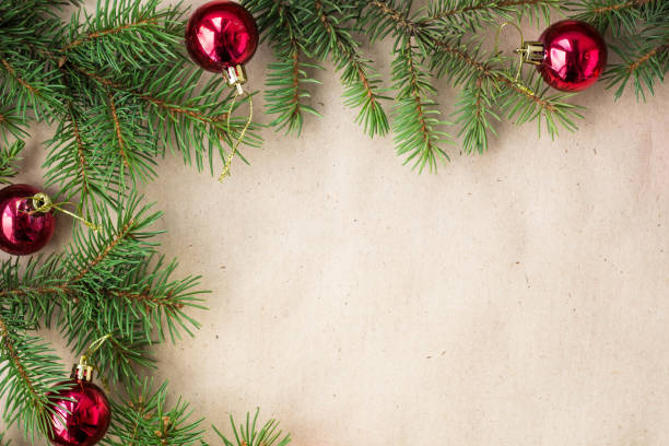 istock Fir tree branches decorated with red christmas balls as border on a rustic holiday background frame with copy space 872782690