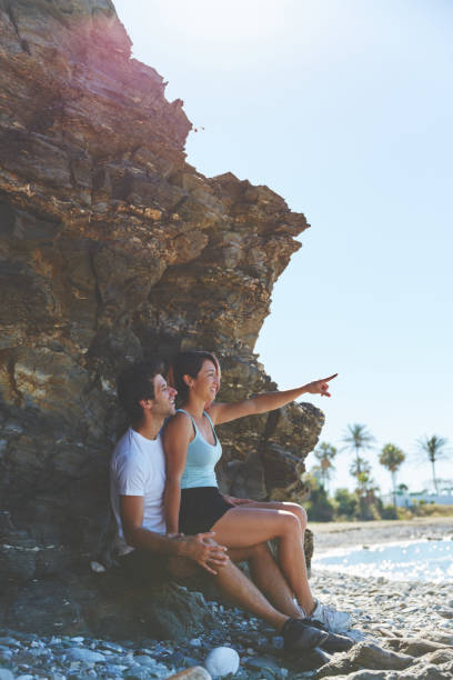 istock Happy girl sitting on boyfriend lap pointing ahead 872786310