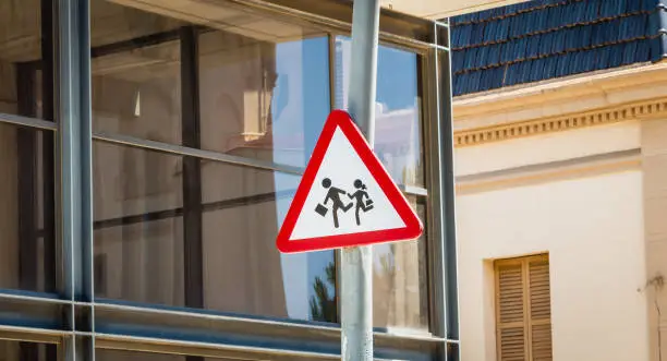 attention to children panel placed in front of a modern glass building in Spain