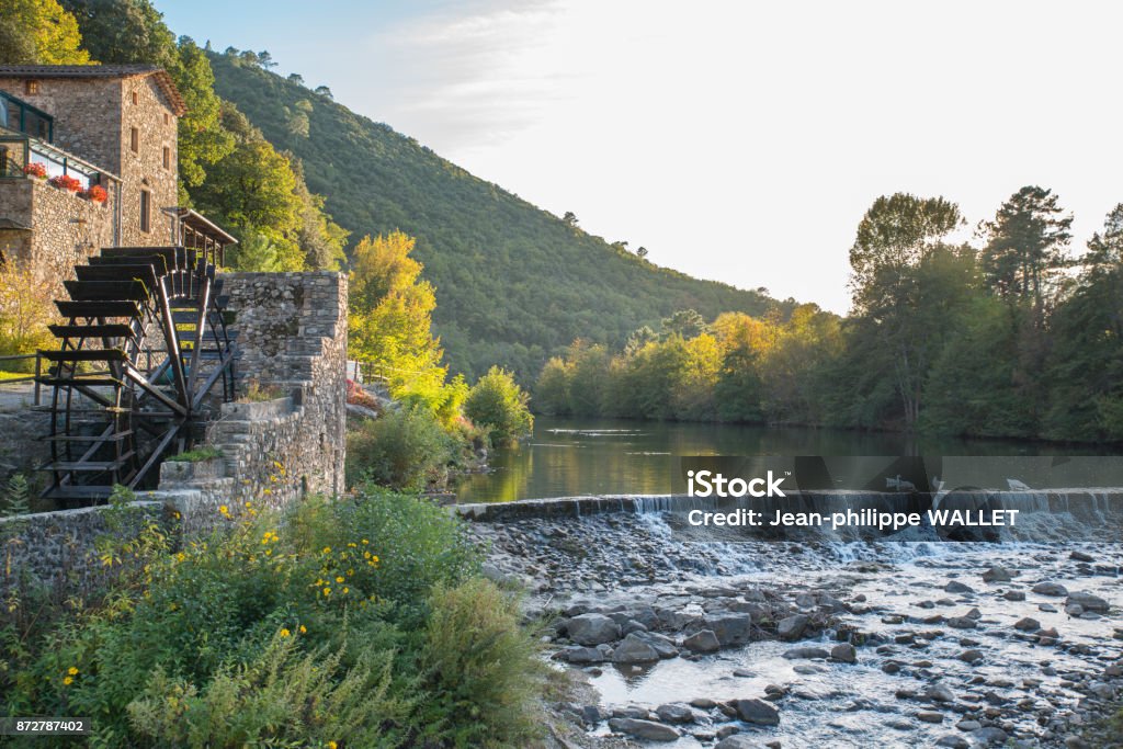 beautiful and colorful river mountain autumn fall season landscape with a watermill at sunset Autumn Stock Photo
