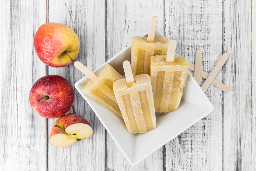 Fresh made Apple Popsicles (selective focus; close-up shot) on a vintage background