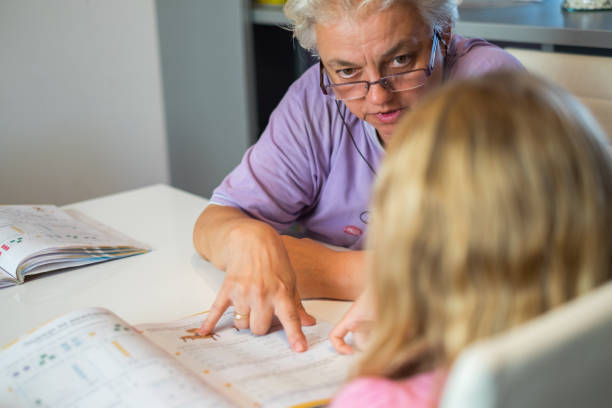 istock Grandmother explaining homework to her granddaughter 872794228