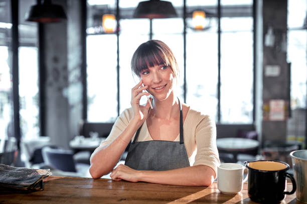 istock Female barista talking with cellphone in cafe. 872798870