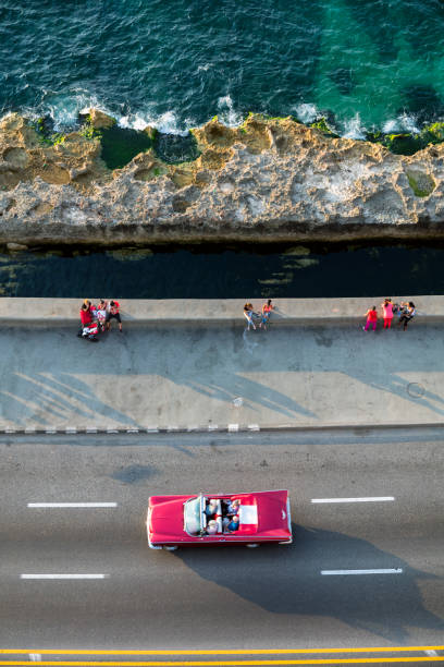 Vintage American car Havana, Cuba Vintage American car, 1959 Buick Electra with tourists, speeding along the Malecon in Havana, Cuba, high angle view. 1950 1959 photos stock pictures, royalty-free photos & images