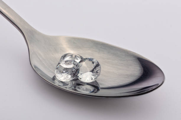 istock Diamonds in the spoon isolated on white background 872799540