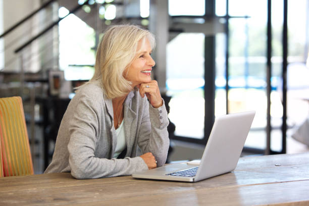istock smiling older woman working laptop computer indoors 872814610