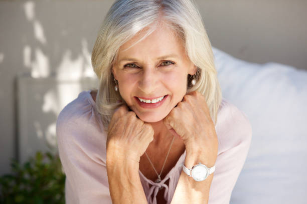 istock smiling older woman with hand in hands outside 872814856