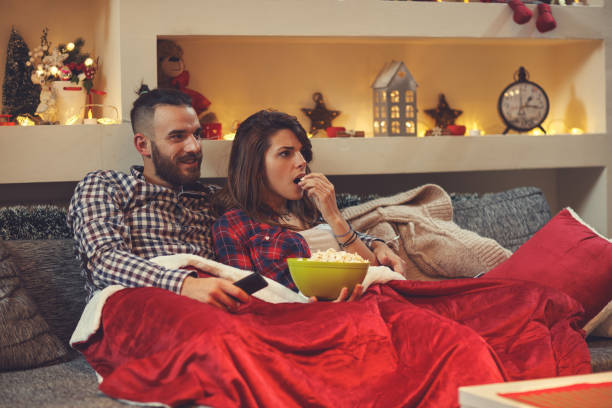 istock Couple eating pop corns while watching tv 872817542