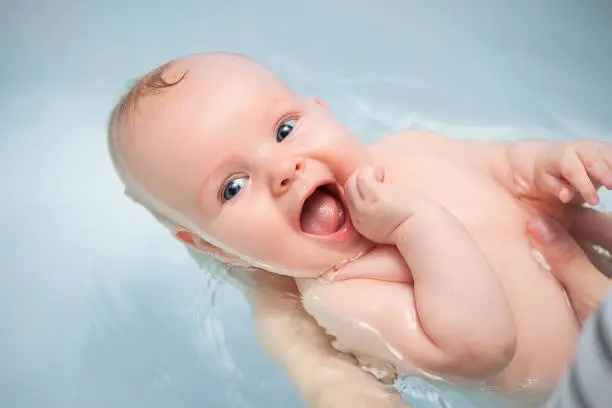 Photo of happy baby enjoying a bath