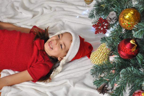 istock Little girl plays with New Year decorations under a Christmas tree 872821876