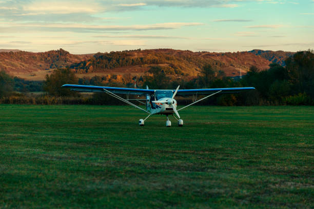 istock Small light blue plane in green field 872832670
