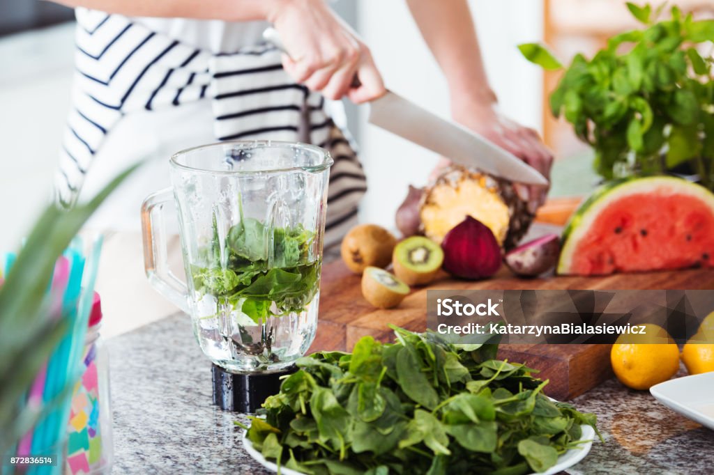 Person preparing coctail with rucola Close-up of person preparing fresh ingredients for energetic coctail with water and rucola Detox Stock Photo