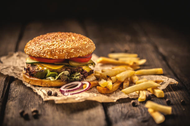 hamburger gustoso con patatine fritte su tavolo di legno - burger french fries cheeseburger hamburger foto e immagini stock