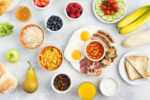 istock Full English breakfast, eggs, bacon, sausages, breads and fruits 872845894