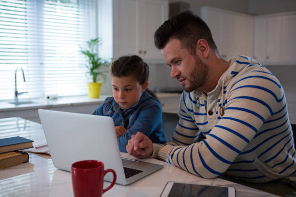 istock Father assisting daughter in her studies 872846064