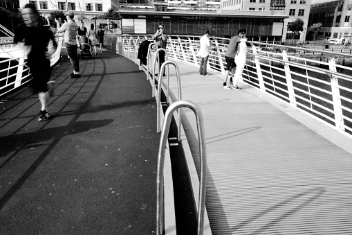 Gateshead, United Kingdom Visitors walking over the Millenium bridge from Gateshead towards Newcastle.  This image shows people walking over the bridge.