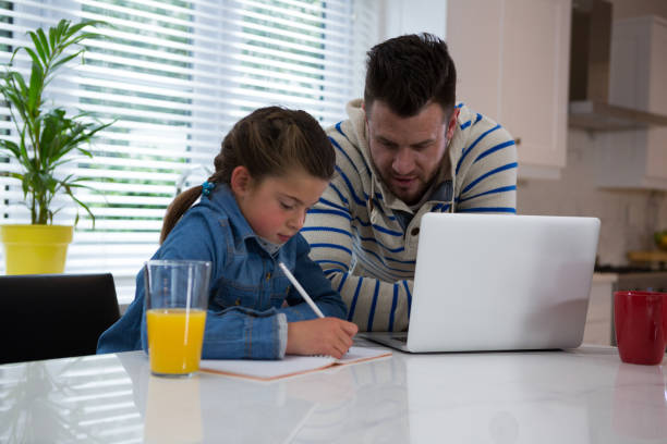 istock Father assisting daughter in her studies 872848500