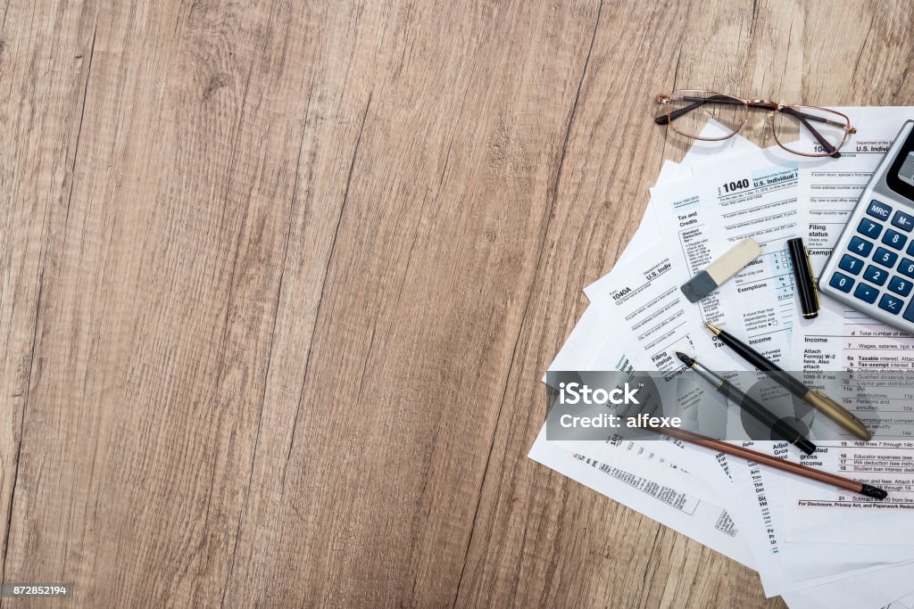 modulo fiscale con blocco note, penna, matita e calcolatrice - Foto stock royalty-free di Modulo per la dichiarazione dei redditi