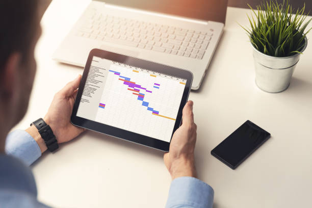 istock project manager looking at gantt chart on digital tablet in office 872861938