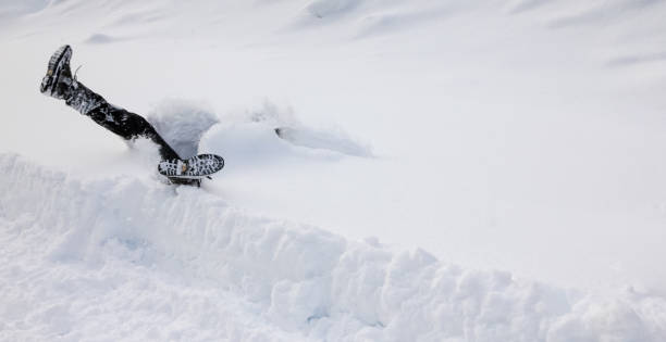 Man is falling headfirst into deep snow. Concept of winterly slippery conditions. Man is falling headfirst and legs up in the air into deep snow. Winterly slippery conditions and dangerous accident concept. deep snow stock pictures, royalty-free photos & images