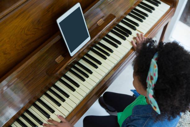 istock Girl playing piano with digital tablet 872865406