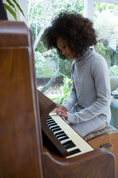 istock Beautiful woman playing piano 872866054