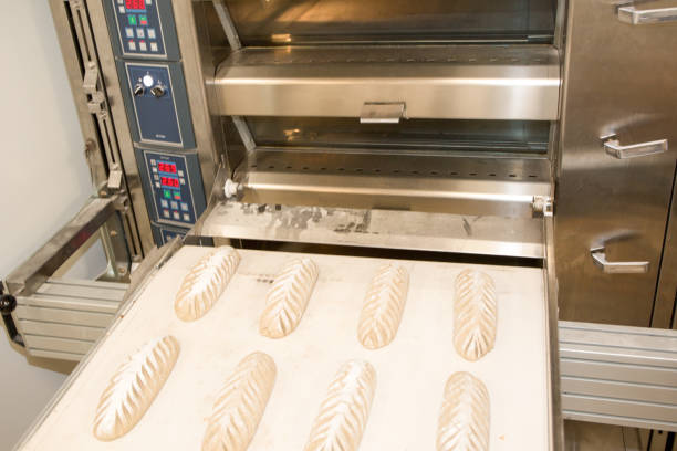 Baker taking fresh baked bread from oven. Manufacturing process Baker taking fresh baked bread from oven. Manufacturing process bread proofer stock pictures, royalty-free photos & images