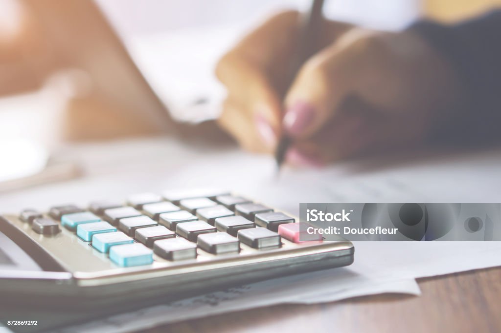 negocios mujer mujer la mano calculando sus gastos mensuales con calculadora en primer plano - Foto de stock de Colección libre de derechos