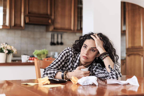 istock Worried woman sitting at home 872874478