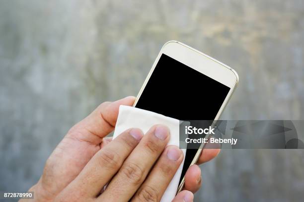 Man Cleaning His Smartphone With A Microfiber Cloth Stock Photo - Download Image Now