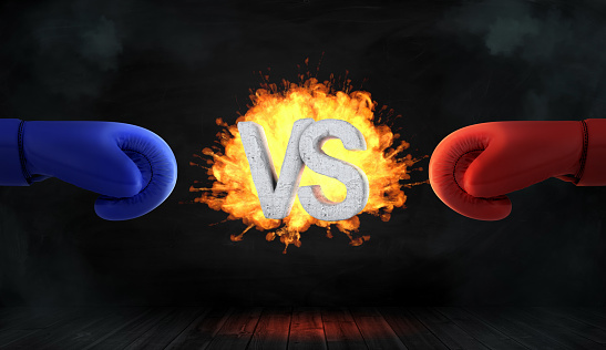 3d rendering of glowing blast with concrete letters VS stands between a red and a blue boxing glove. Business competition. Fighting match. Confrontation.