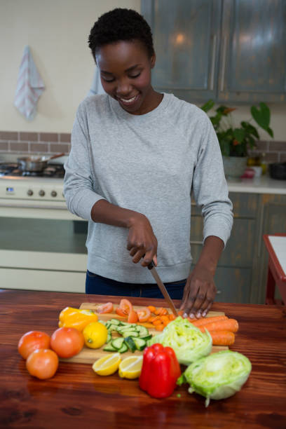 istock Beautiful woman chopping vegetables in kitchen 872896466