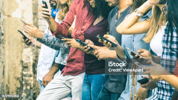 Group Of Multicultural Friends Using Smartphone Outdoors People Hands Addicted By Mobile Smart Phone Technology Concept With Connected Men And Women Shallow Depth Of Field On Vintage Filter Tone Stock Photo - Download Image Now