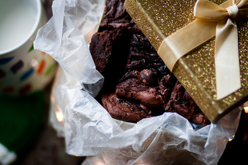 A gift box full of brownies with a christmas mug