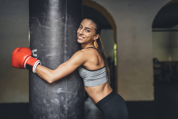 istock female boxer with punching bag 872919536
